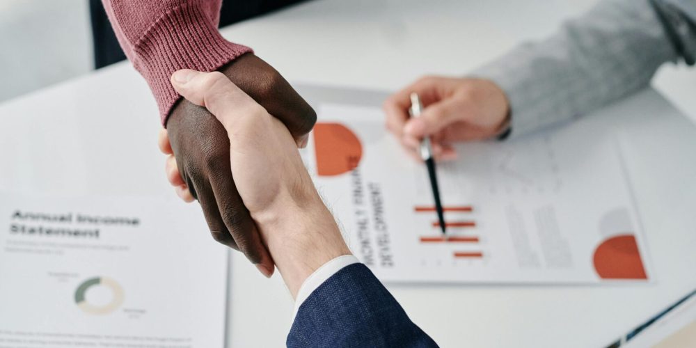 pexels-photo-7109289-7109289 Professional handshake over financial documents symbolizes successful business partnership and teamwork.